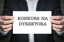 Trzymające ręce kartkę z napisem: konkurs na dyrektora